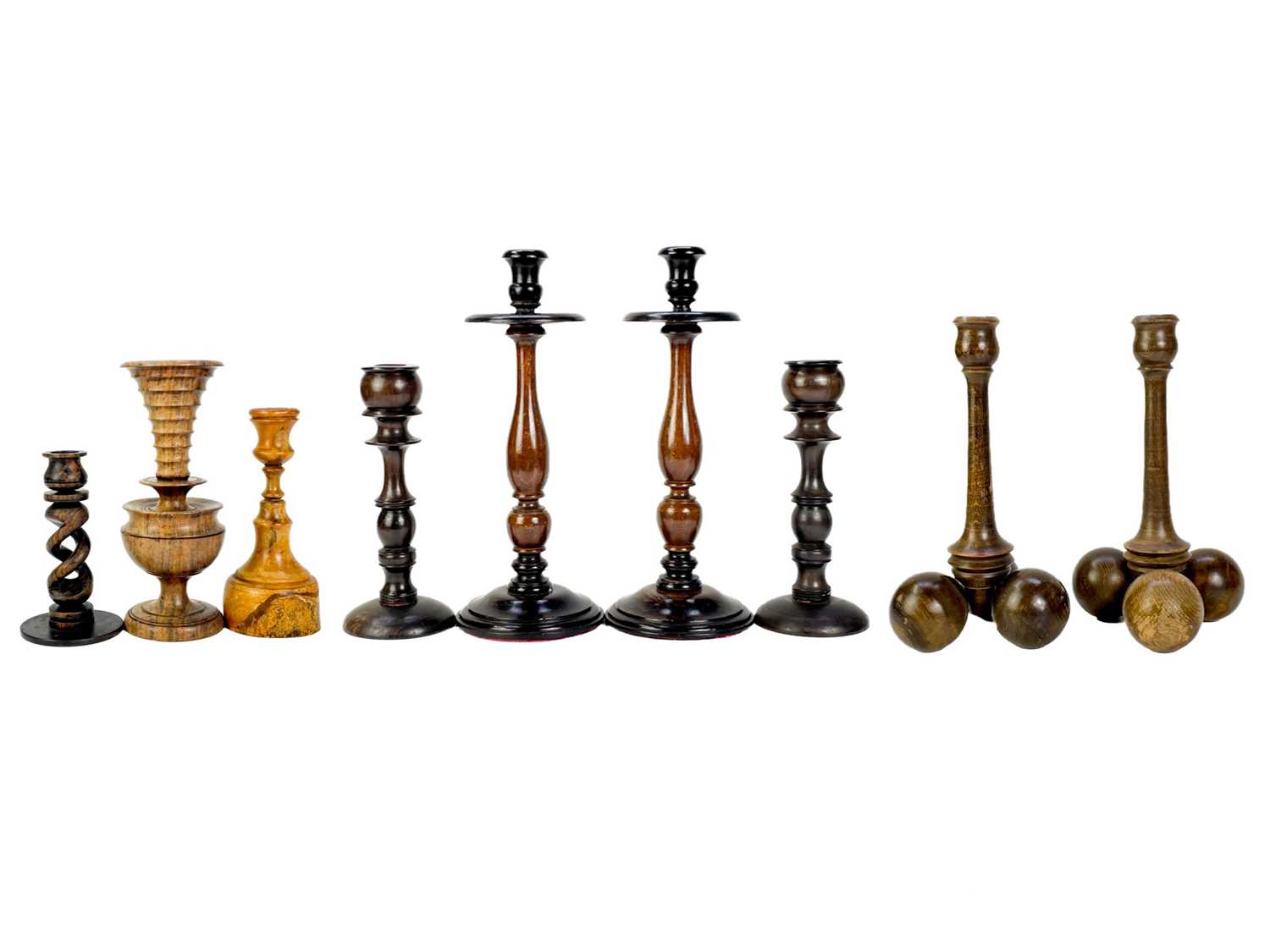 A collection of nine treen candlesticks.