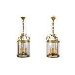 A pair of circular glazed brass hall lanterns.