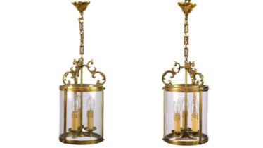 A pair of circular glazed brass hall lanterns.