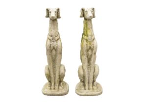 A pair of large reconstituted stone seated whippet garden ornaments.