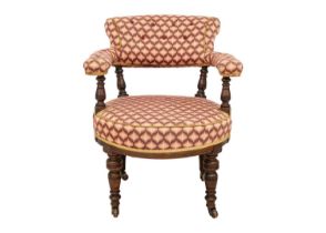 A Victorian walnut upholstered tub chair.