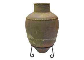 A terracotta olive jar, with two bands of applied decoration, raised on metal stand.