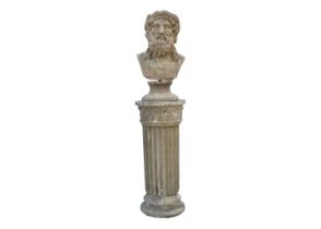 A reconstituted stone sculpture of a male head, raised on fluted column.