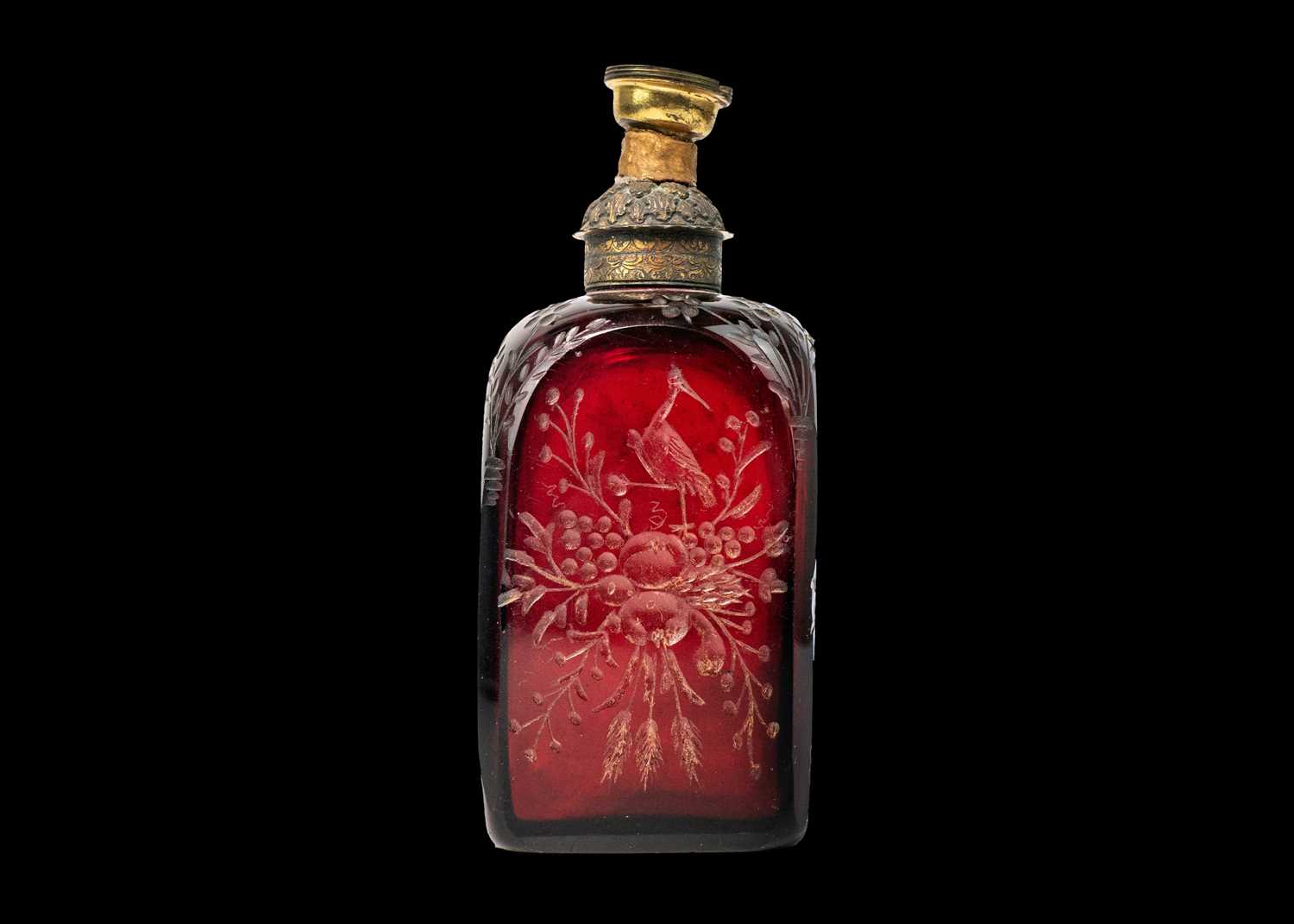 An early 18th century ruby glass decanter, etched with exotic birds, flowers and foliage.