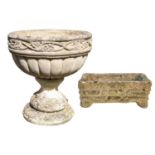 A composition stone urn shape garden planter with fruiting vine decoration.