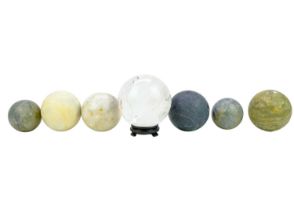 A collection of seven large sphere shaped minerals.