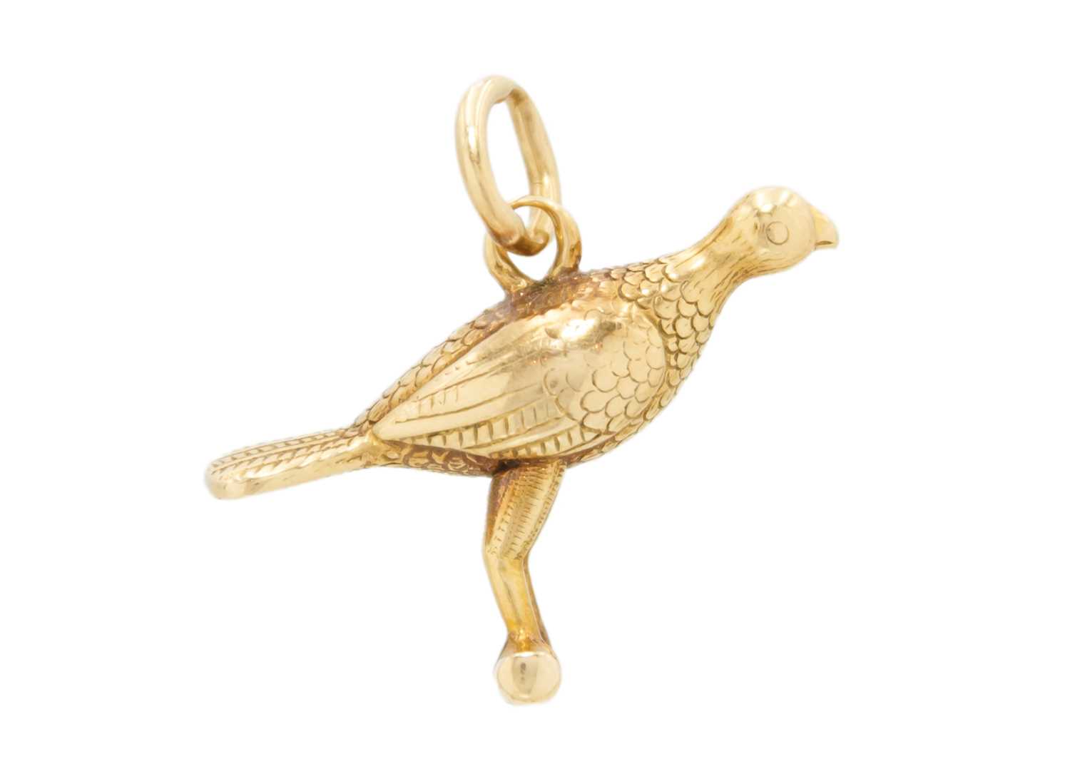 A high purity gold (tests 18ct) bird on a perch charm pendant.