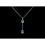 An 18ct white gold blue topaz and diamond set pendant necklace.