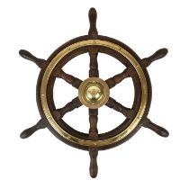 A six spoke teak and brass bound yacht wheel by Simpson Lawrence.