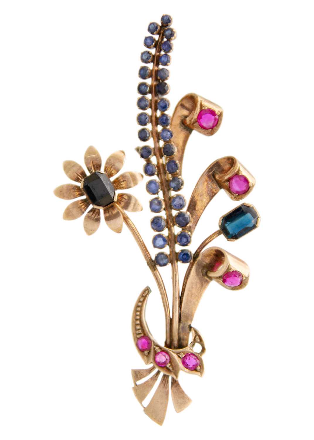 A rose gold (tests 9ct) ruby and sapphire set floral spray brooch.