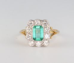 A yellow metal 18ct Edwardian style emerald and diamond cluster ring, emerald approx. 1.1ct, the