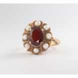 A yellow metal 9ct oval garnet and pearl ring size M, 4.4 grams