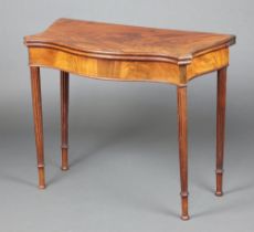A Georgian mahogany tea table of serpentine outline raised on turned and fluted supports, 73cm h x