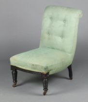 A Victorian nursing chair upholstered in green material, raised on turned supports 76cm h x 49cm w x