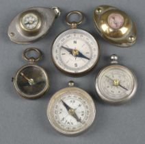 A collection of 6 miniature compasses