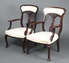 A pair of Edwardian mahogany open arm chairs with vase shaped slat backs and upholstered seats,