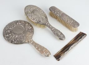 A Victorian style repousse silver dressing table set comprising hand mirror, hair brush, clothes