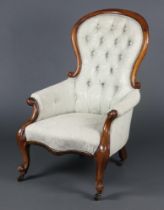 A Victorian mahogany show frame armchair upholstered in green buttoned material, raised on