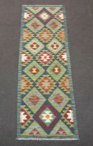 A black, brown and green ground Maimana Kilim runner with diamond design to the centre 197cm x 66cm