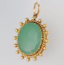 A yellow metal pendant set with a green hardstone 40mm, 12.3 grams