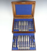 A walnut canteen containing a set of 12 silver dessert knives and forks, London 1867, maker George W