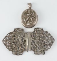 An Indian repousse white metal locket together with a pierced buckle decorated with birds, 69 grams