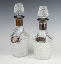 A pair of cut glass mallet shaped decanters and stoppers, 1 with a silver collar, 29cm, both with