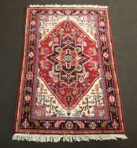 An Afghan red, white and blue ground rug with diamond medallion to the centre within a multi row
