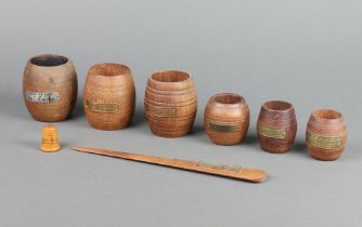Six First World War turned teak and brass match holders, formed from teak of various war ships - HMS