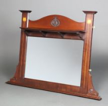 An Art Nouveau rectangular plate mirror contained in a mahogany frame, the upper section fitted a