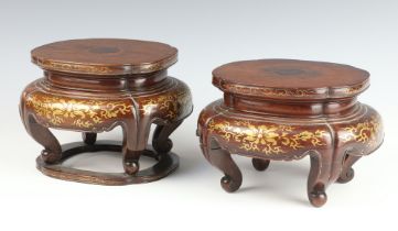 A pair of 19th Century Chinese hardwood vase stands with formal gilt scroll decoration, raised on