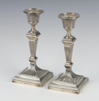 A pair of Victorian silver tapered square candlesticks on stepped bases London 1889, 17cm