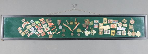 54 various First World War and later paper and cloth lapel pins contained in an ebonised frame