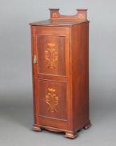 An Edwardian Art Nouveau inlaid mahogany music cabinet with raised shaped back, fitted shelves