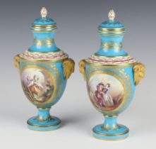 A pair of 19th Century Sevres turquoise ground vases and covers with mask handles and panels of