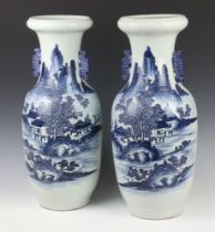 A pair of 18th Century style blue and white baluster vases decorated with extensive landscape scenes
