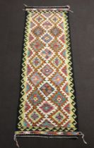 A black, white, blue and brown ground Chobi Kilim runner with all over stylised diamond design 248cm