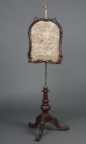 A Victorian pole screen with machine tapestry panel raised on a gilt column and carved walnut tripod