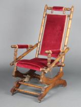 A 19th Century turned beech American rocking chair upholstered in red material 108cm h x 55cm w x