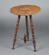 An Edwardian circular mahogany cricket table with pie crust edge, raised on turned supports with Y