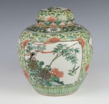 A Chinese famille vert ginger jar decorated with panels of birds amongst flowers on a ground of