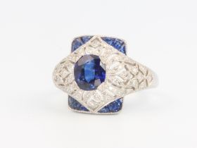 A white metal Edwardian style sapphire and diamond cocktail ring set with an oval sapphire