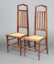 A pair of Edwardian mahogany stick and rail back bedroom chairs with woven rush seats, on square