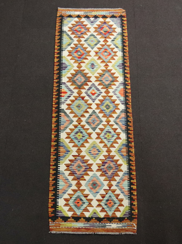 A yellow, white and black ground Chobi Kilim runner with diamond decoration to the centre 196cm x
