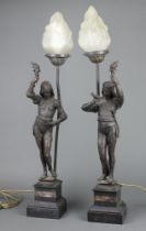 A pair of 19th Century spelter figures depicting 17th Century characters, both bearing torches,