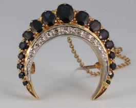 An 18ct yellow gold crescent diamond and sapphire brooch, the 14 brilliant cut diamonds each at 0.