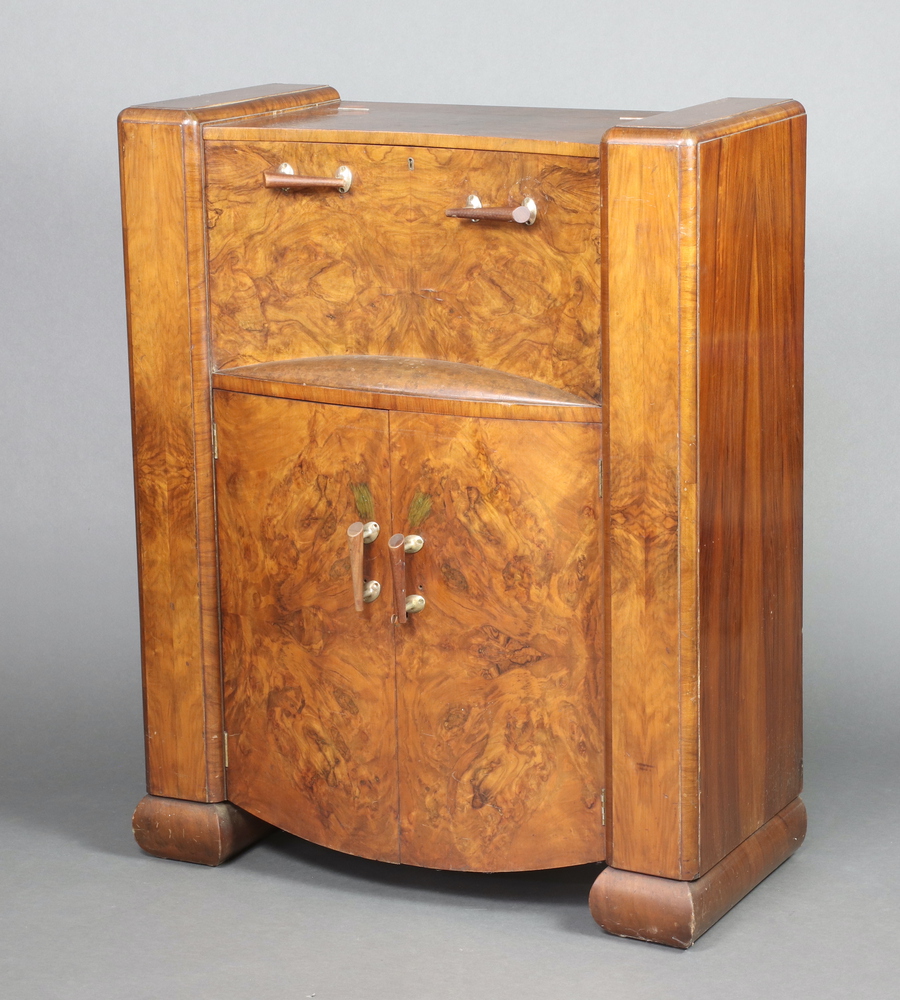 In the manner of Epstein, an Art Deco figured walnut cocktail cabinet with hinged lid and cupboard