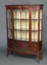 An Edwardian mahogany bow front display cabinet with moulded cornice, fitted shelves enclosed by