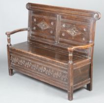 A Victorian carved oak settle with hinged lid raised on square supports 102cm h x 132cm w x 44cm d (