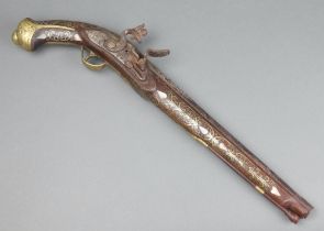 An 18th/19th Century Eastern flint lock pistol with 33cm barrel inlaid "silver", having walnut